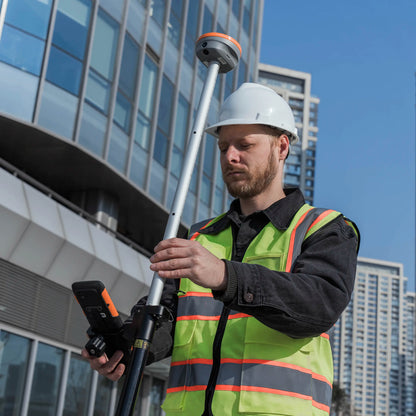 Topógrafo utilizando el receptor GNSS CHCNAV i76 IMU RTK y la controladora HCE600 en un levantamiento de campo con realidad aumentada.