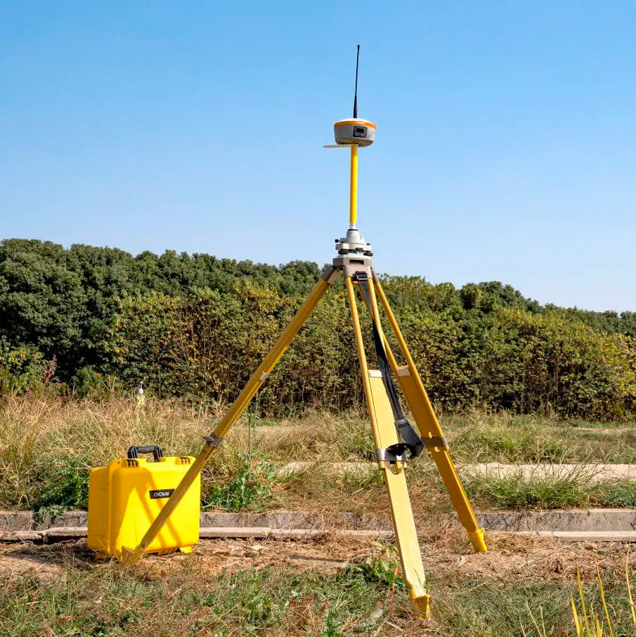 Estación base CHCNAV iBase GNSS desplegada en campo proporcionando correcciones RTK a receptores GNSS para topografía de alta precisión.