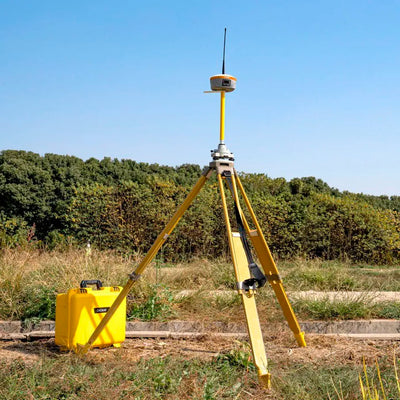 Estación base CHCNAV iBase GNSS desplegada en campo proporcionando correcciones RTK a receptores GNSS para topografía de alta precisión.