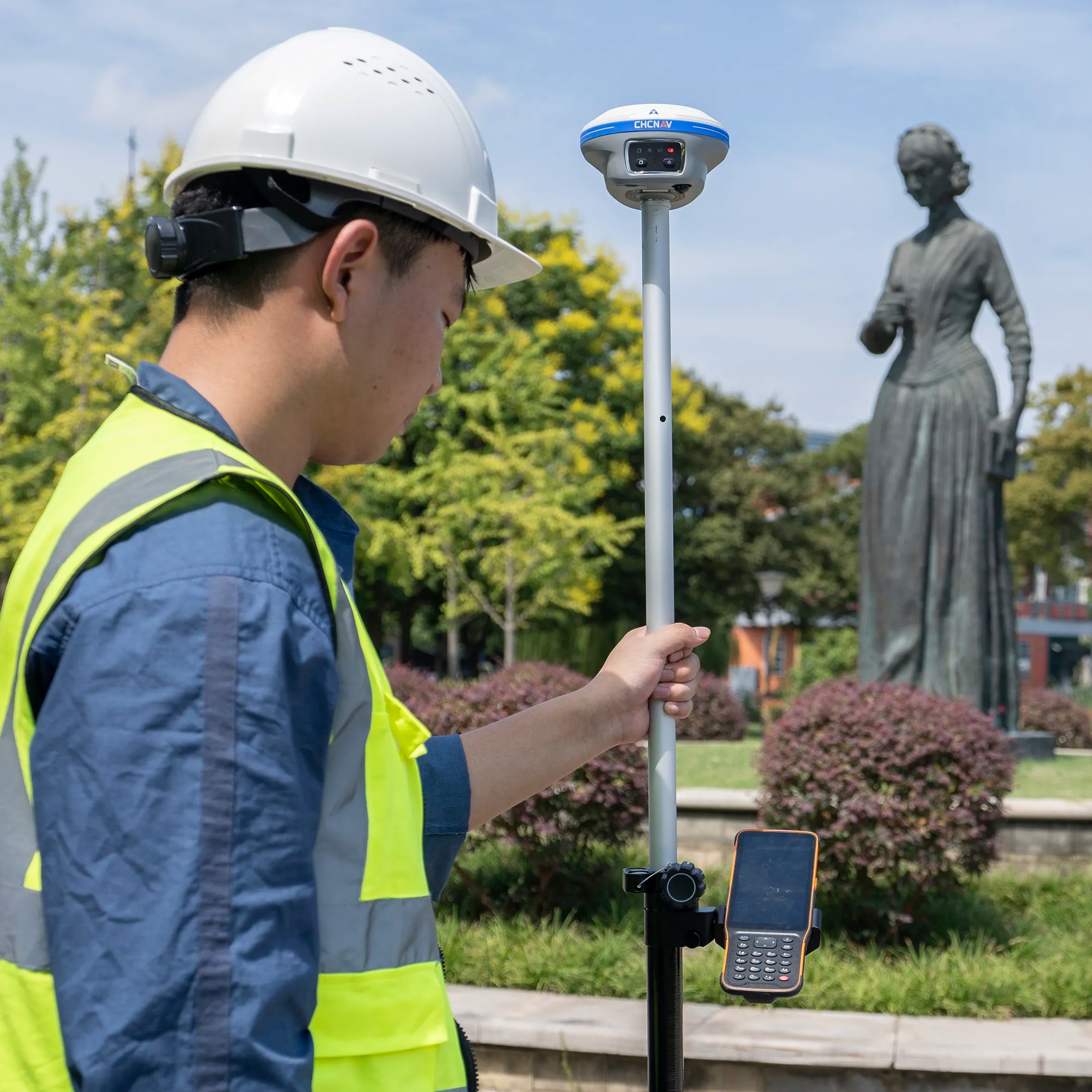 Topógrafo utilizando el receptor GNSS CHCNAV i89 IMU RTK y la controladora HCE600 en un levantamiento con fotogrametría y realidad aumentada.