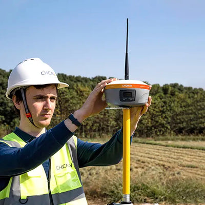 Base GNSS CHCNAV iBase operando en levantamientos topográficos, transmitiendo datos UHF a receptores GNSS para posicionamiento centimétrico.